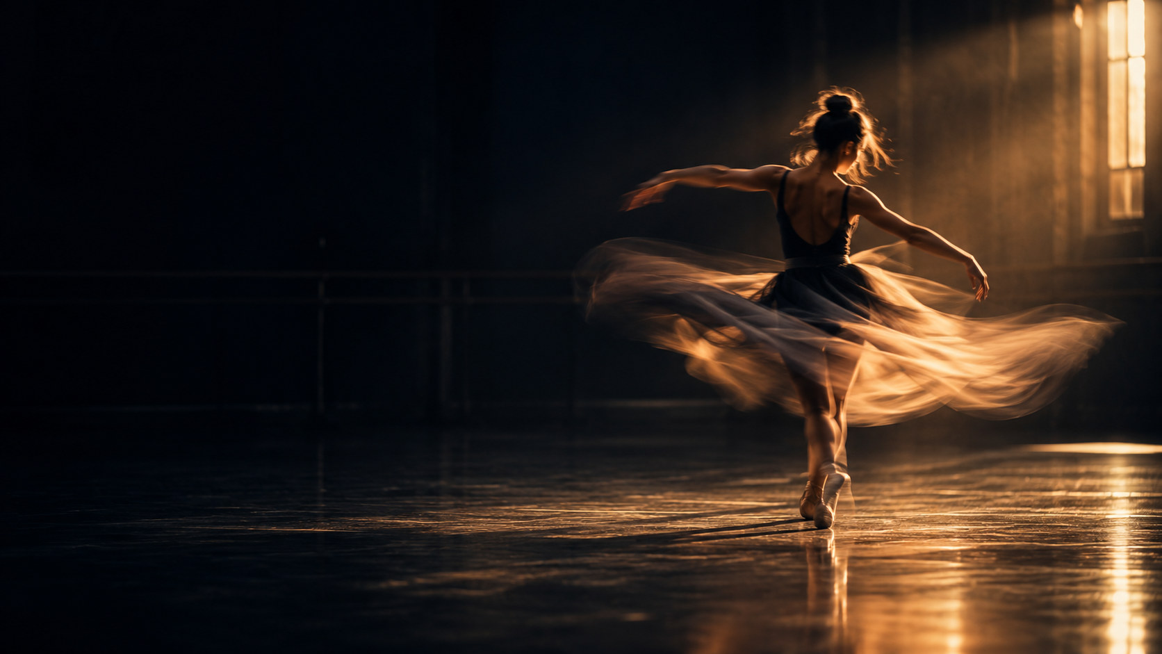 A dancer turning in a dark rehearsal studio